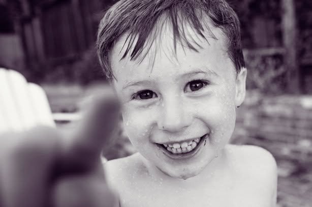 A smiling child reaching toward the camera
