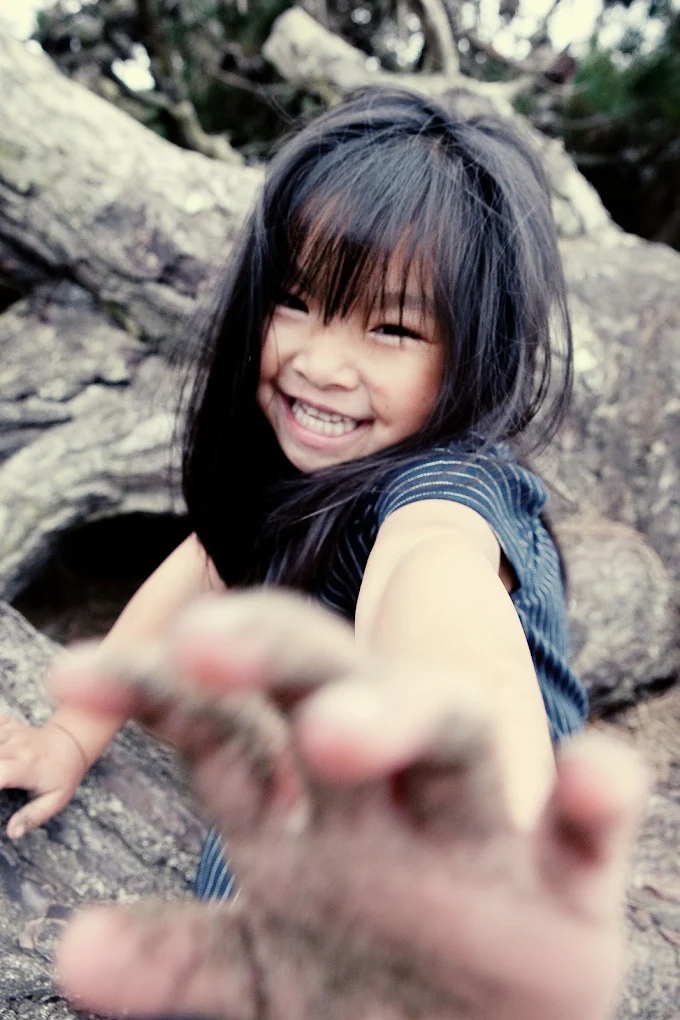 A laughing child reaching toward the camera